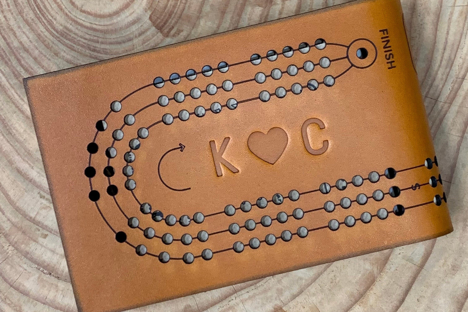 Honey leather folding travel cribbage with the initials K (heart) C monogrammed (embossed) into the leather