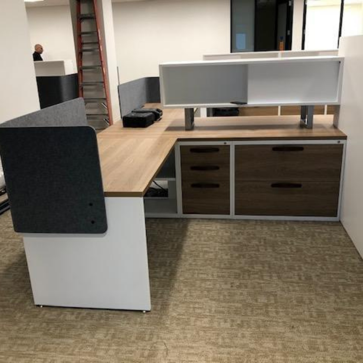 Customer photo of the black Hawthorne handle installed flat with two sets of hardware on a series of office cubicles on a grey natural wood.