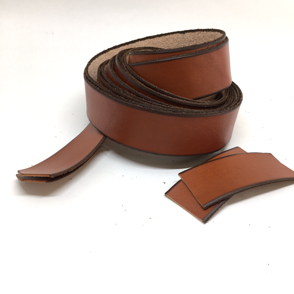 White background photo showing what comes in the package: a set of two very long leather straps wrapped in a coil and two small pieces of leather strap used as gap fillers for the brake hoods