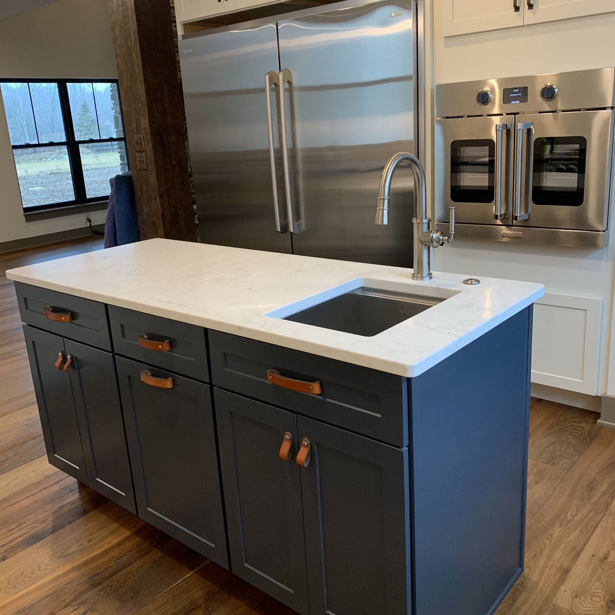 Customer photo of a kitchen island with dark blue cabinetry and honey leather handles: the contrast between the orange-ish cognac color and the dark blue is very pretty. 