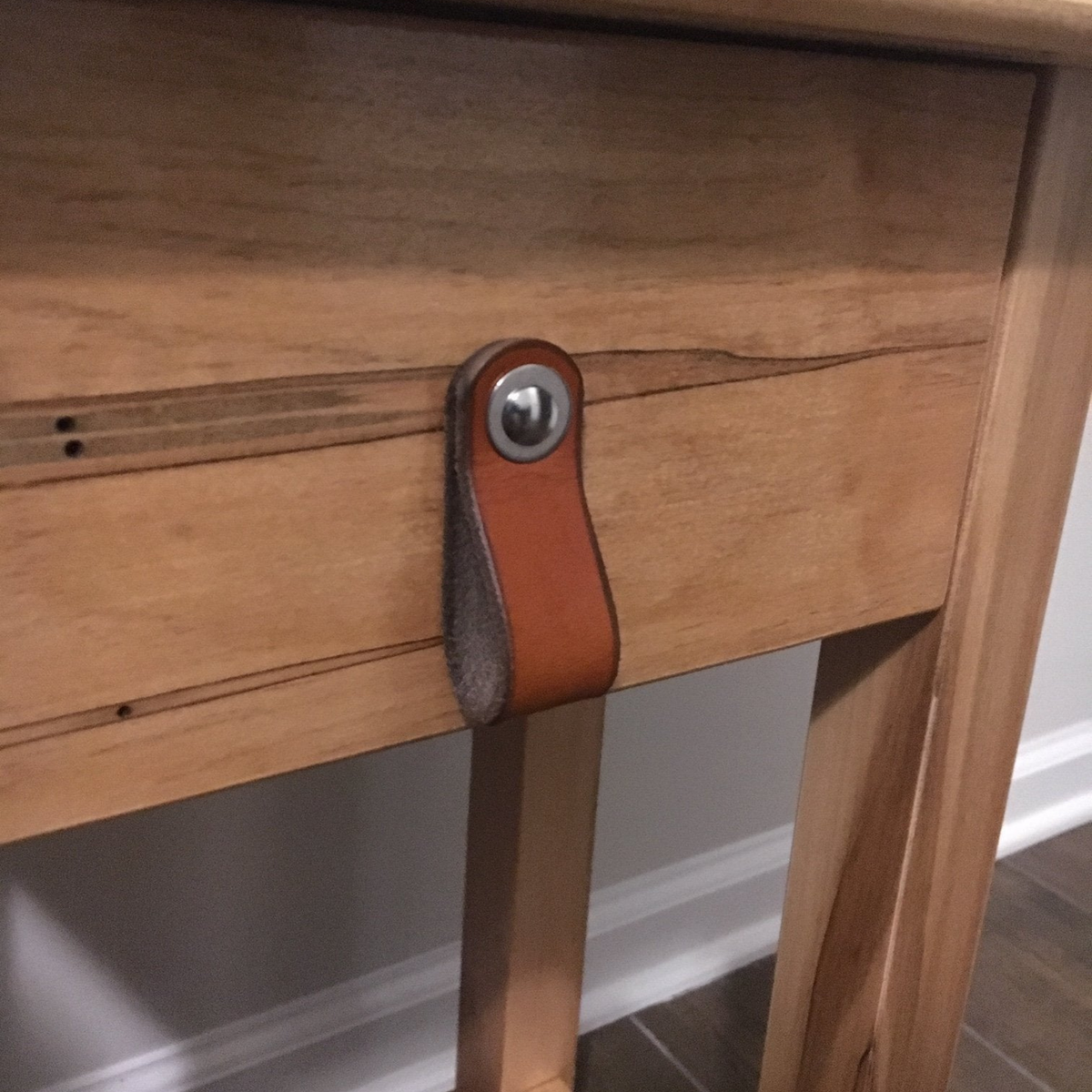 Customer photo of a honey Hawthorne leather loop pull on a custom made buffet from a beautiful tiger-striped wood.