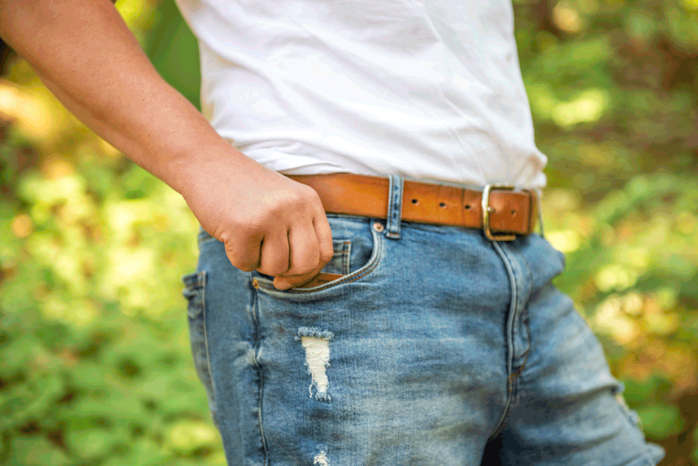 Short GIF video showing a man sliding a Mini Deluxe leather travel cribbage board into the front right pockets of his denim jeans.