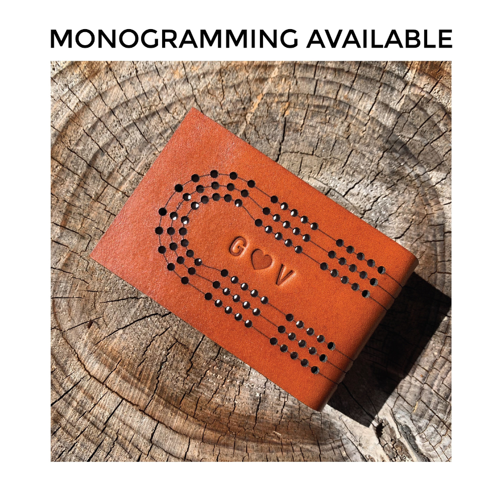 &quot;monogramming available&quot; meme shows the leather space inside the travel cribbage tracks with stamped initials and a heart. 