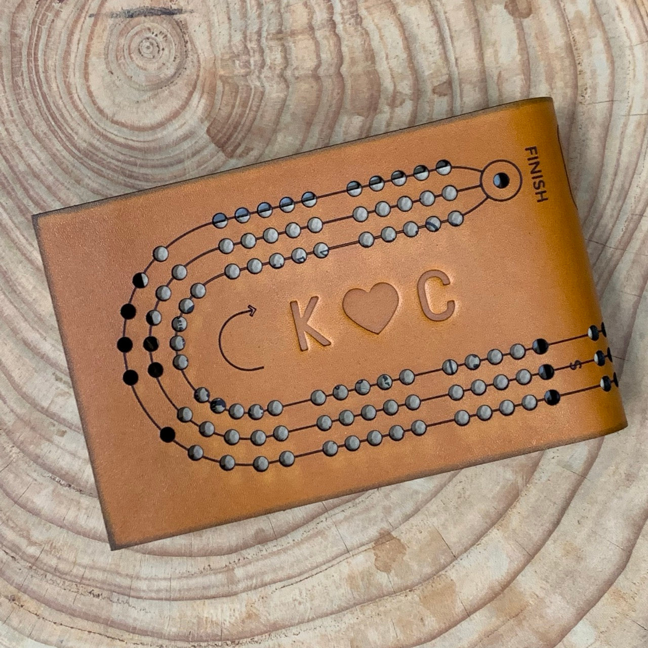 Monogrammed leather folding cribbage board with a couple's initials and a heart