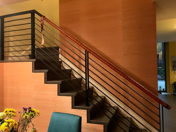 A stairway bannister wrapped in coils of leather