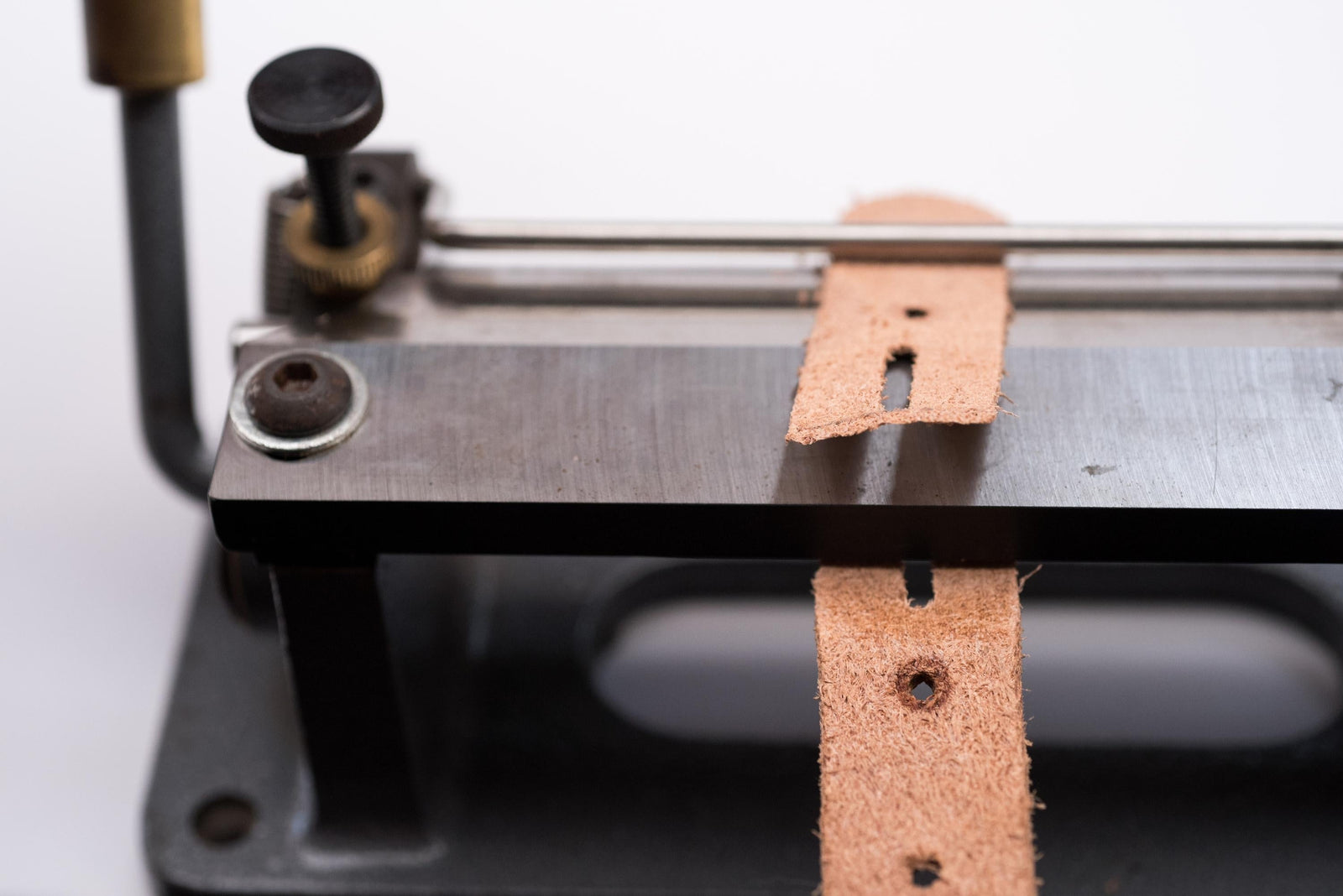 Using a leatherworking tool to shave or split off the rough backside of the leather
