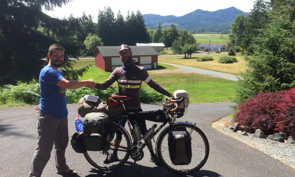 A bikepacker standing in the Walnut Studiolo driveway on the Oregon Coast