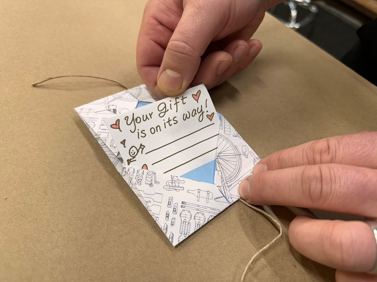 A gift note being assembled, handwritten, Your gift Is on its way!