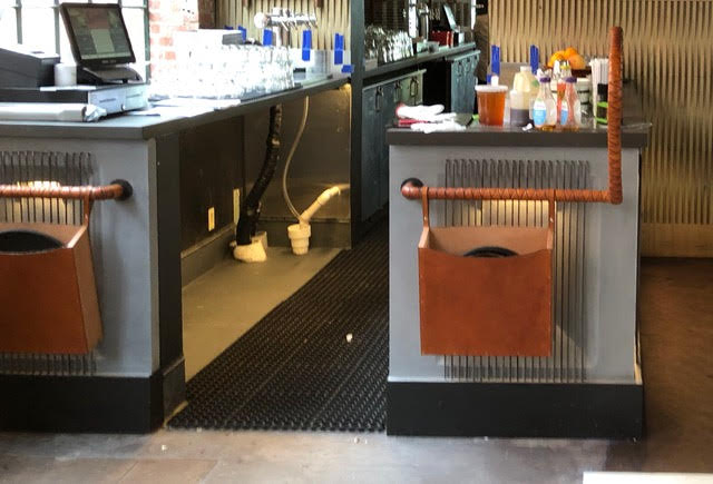 A leather-wrapped bar service rail in a high-end restaurant