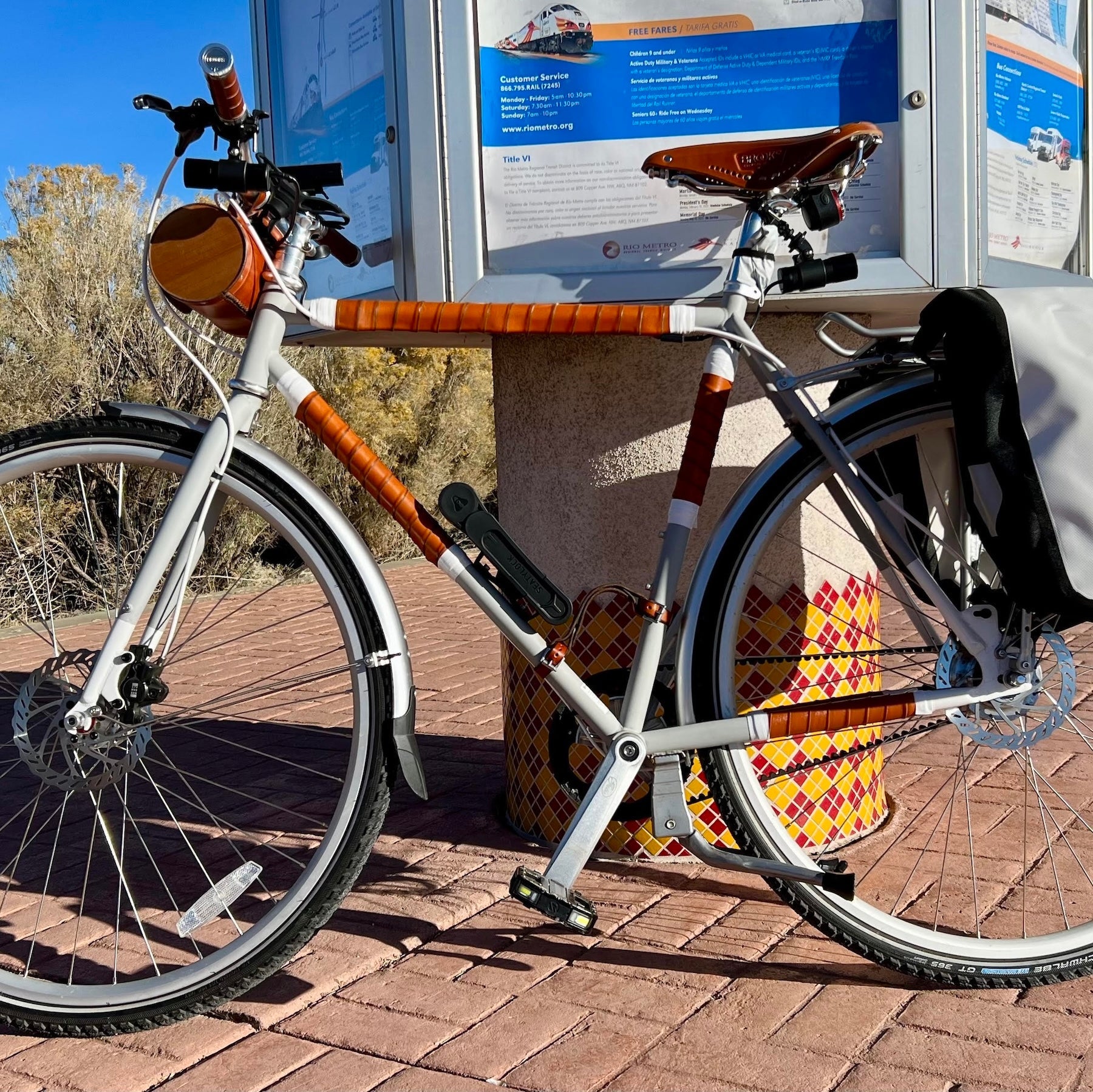 A customer's bicycle at a metro station with honey leather bicycle frame wraps on his top tube protector, seat tube protector, down tube protector, and chainstay guard, using leather coil wraps