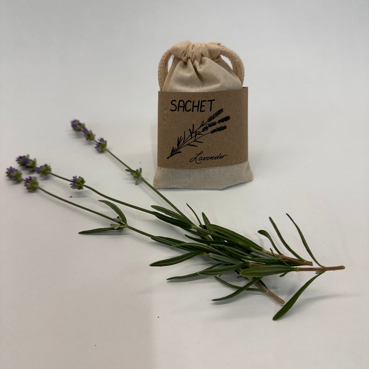 Lavender sachet with lavender sprigs on a light gray background