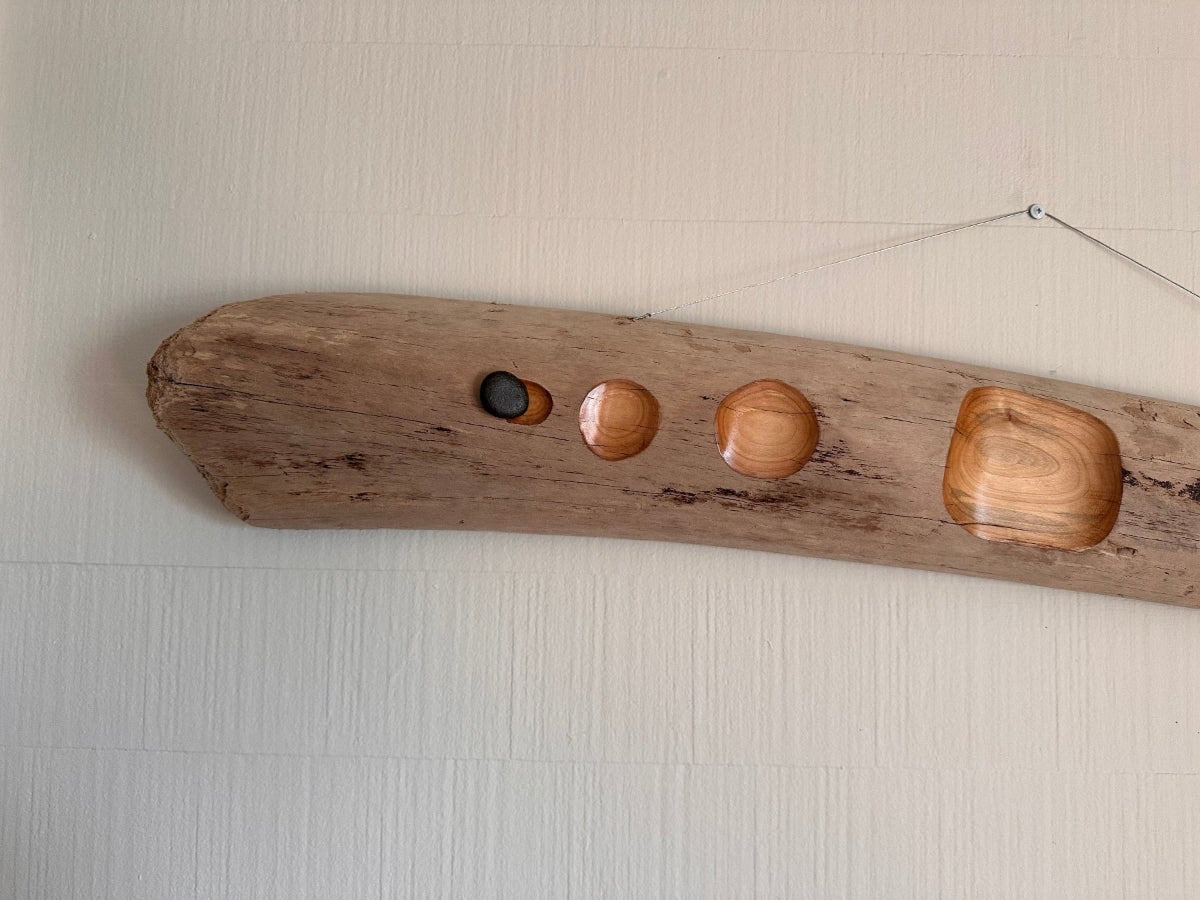 Wooden driftwood with four natural wooden sanded areas on a beige background