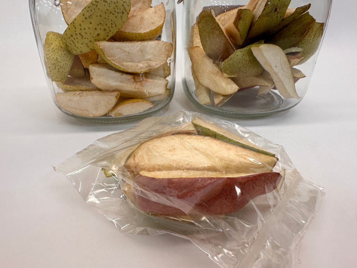 Dried pears in glass jars and a clear  sealed plant cello snack bag on a white background