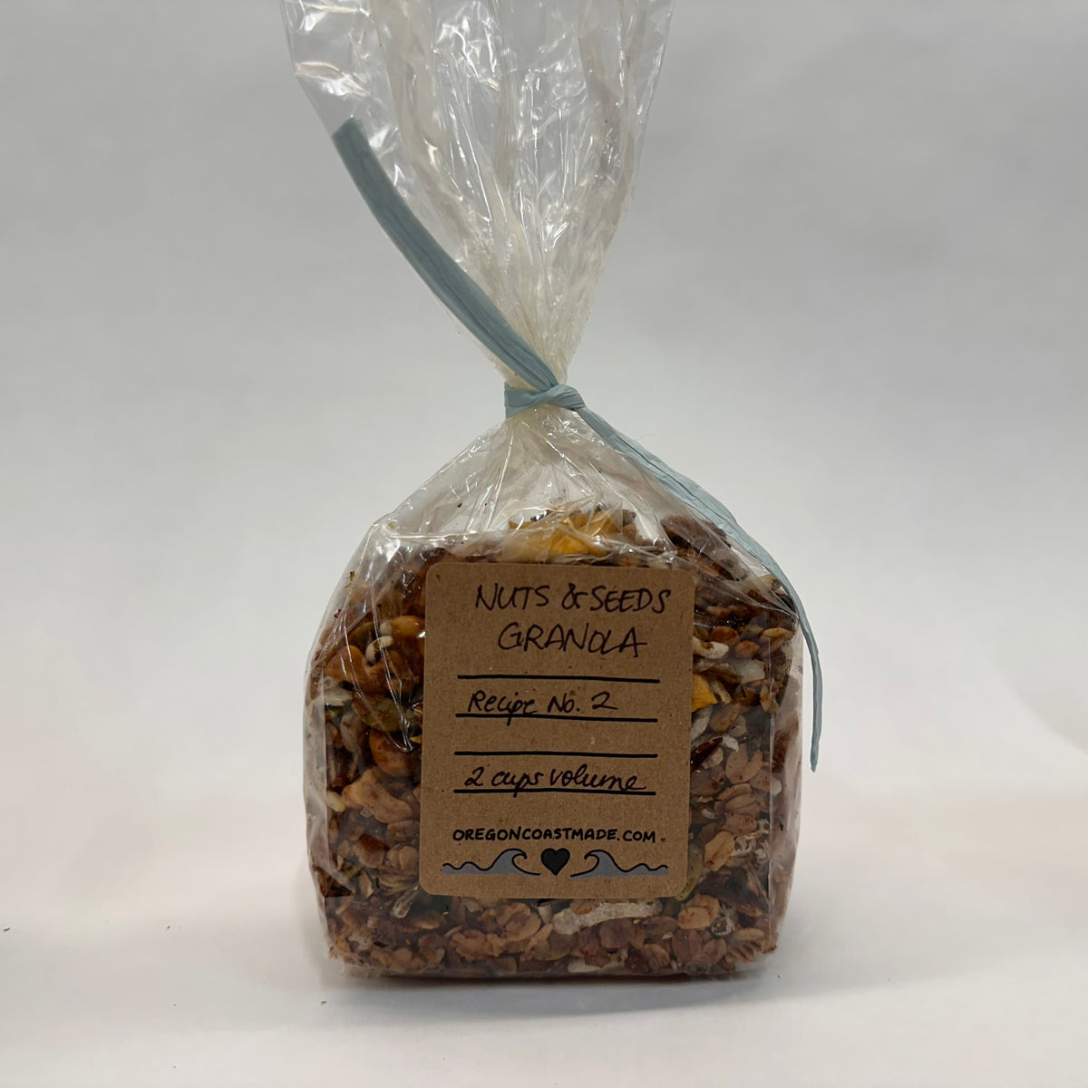 Bag of nuts and seeds granola with a label on a white background that says 2 cup volume. There is room in the bag to double the amount to 4 cups, it&#39;s tied on the top with a piece of paper ribbon. 
