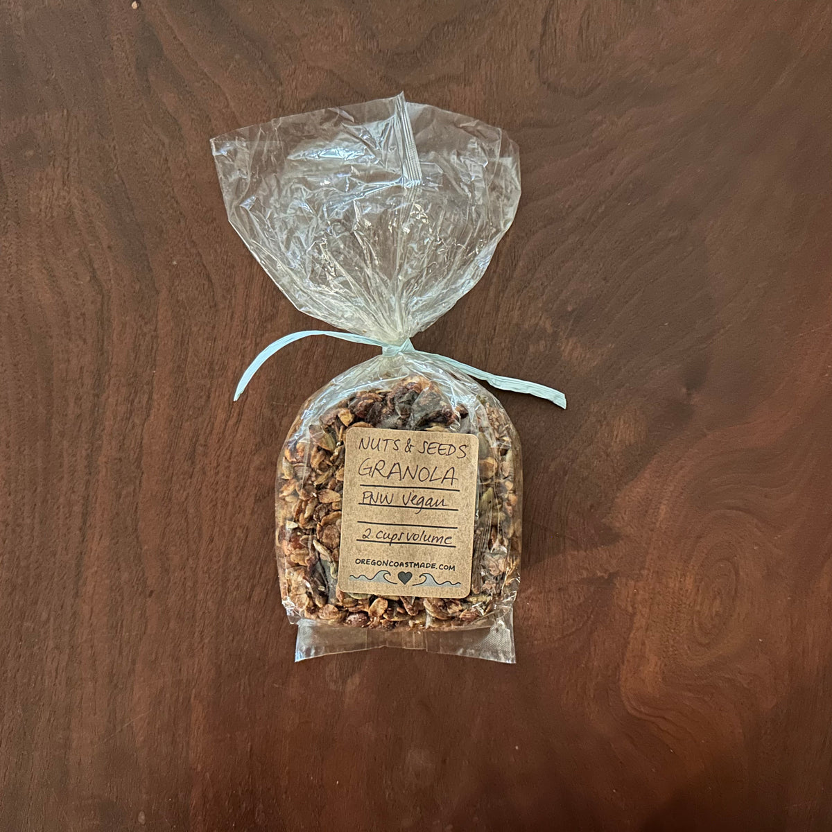 Packaged bag of granola on a wooden surface with a visible label 2 cups