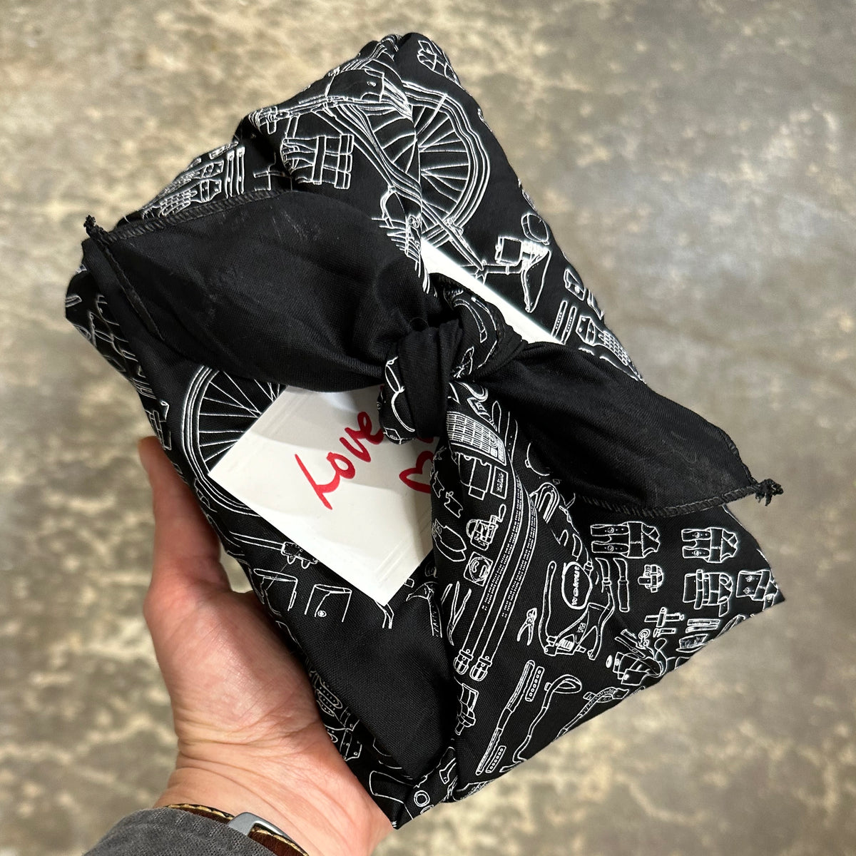 A gift wrapped in a black furoshiki cloth bandana