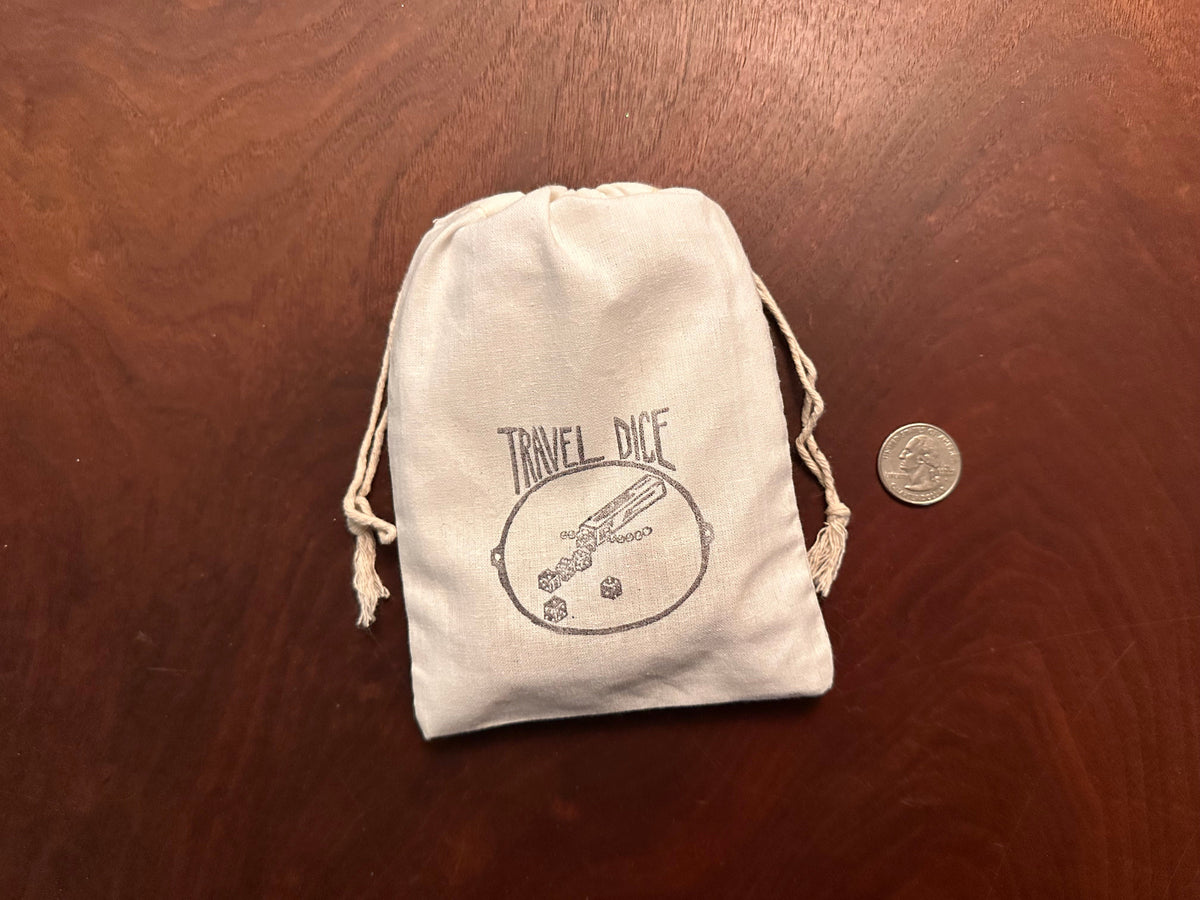 The Travel Yacht kit shown how it arrives and how it travels, with the parts inside the 5&quot; x 7&quot; bag, tied with a double-drawstring, and a quarter next to it for scale. 