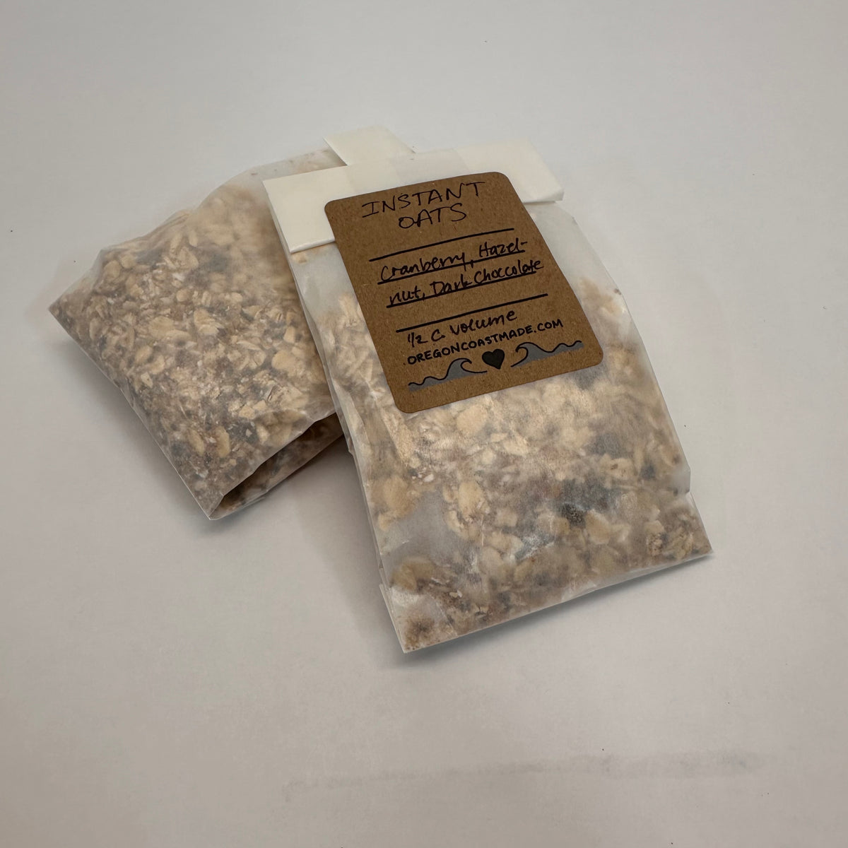 Two packages of instant oats with a label on a gray background