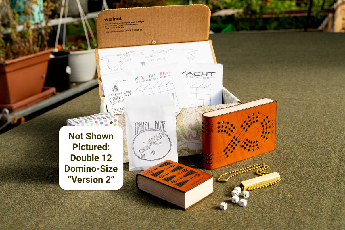 &quot;Best of the Best&quot; Travel games gift bundle shown with a handcrafted memory box, &quot;places I&#39;ve been&quot; keepsake map, printed scorecards for Mexican Train, Yacht / Yatzy, and Farkle / 10,000 dice game, travel dice with brass tube, leather cribbage board, leather backgammon board, and &quot;shown not pictured: double 12 travel dominoes playing cards version 2&quot;