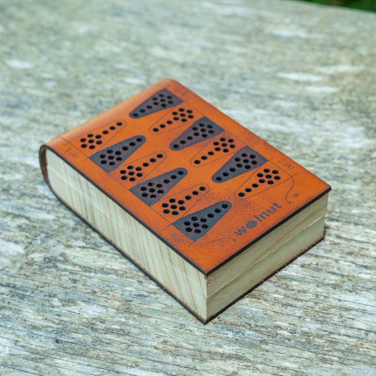 A folding leather backgammon board, shown close-up closed and secure with magnets