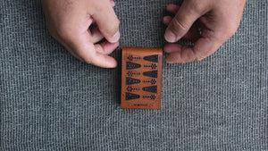 Short video, close-up, bird's eye view, of a man's hands on a table opening a folding travel backgammon board, pulling out the parts and pieces, and setting up a game for play