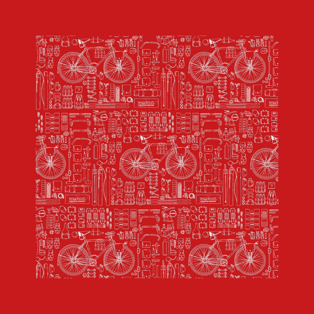 Red version of bicycle print bandana. Print is repeated with a thick black border and features a bicycle with a variety of walnut studiolo accessories. The drawings are of a technical blueprint style.