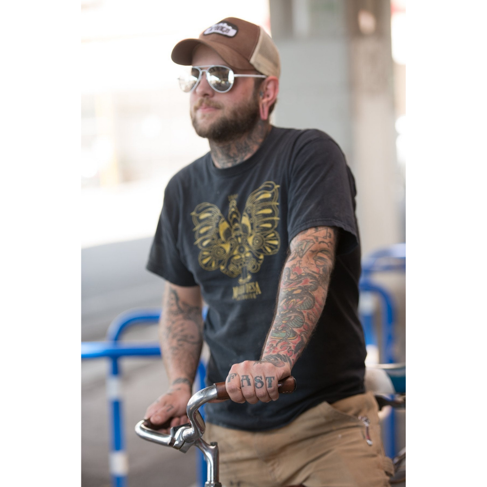 Tattooed man resting his hand on a bicycle city bar wrapped in a dark brown leather grip that has &quot;porthole&quot; round cutouts for finger holds. The man&#39;s hand tattoos say &quot;HOLD FAST&quot;