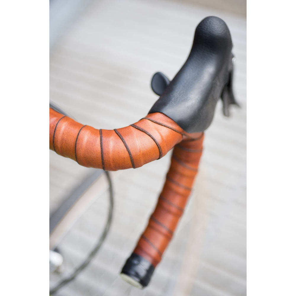 Bird&#39;s eye view looking down on bicycle drop bars with honey leather coiled around handlebars