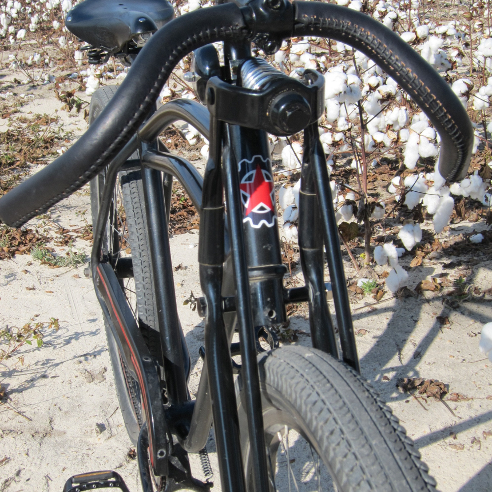 Customer bike photo of a gravel hopper with downturned cafe racer handlebars wrapped in black leather sew-on bar tape.
