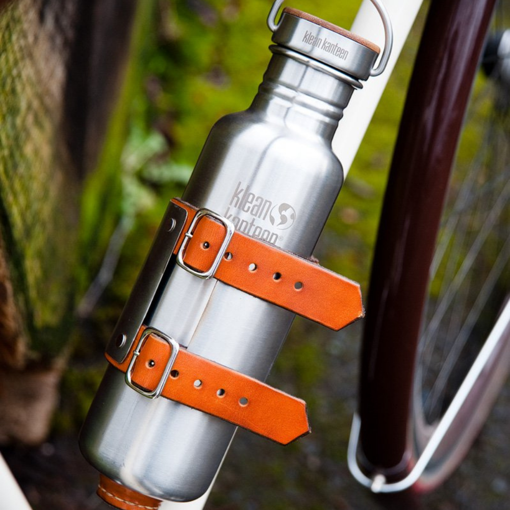 Upcycled bicycle water bottle holder with leather straps showcased
