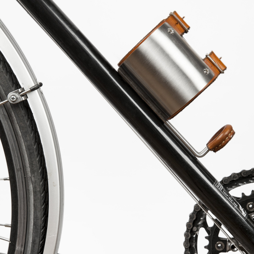 Empty leather-lined upcycled water bottle holder mounted on black bike frame