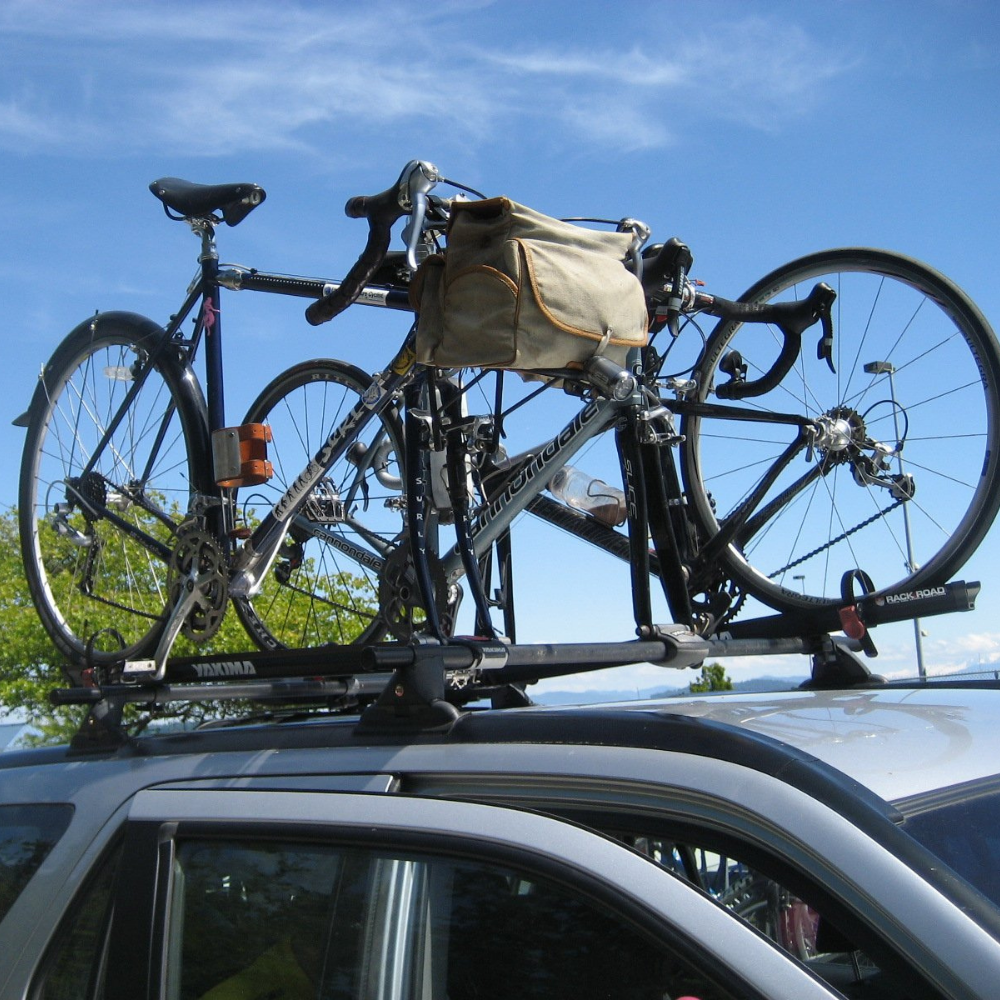 Bicycles mounted on top of SUV, one has the upcycle cage mounted to the bicycle frame