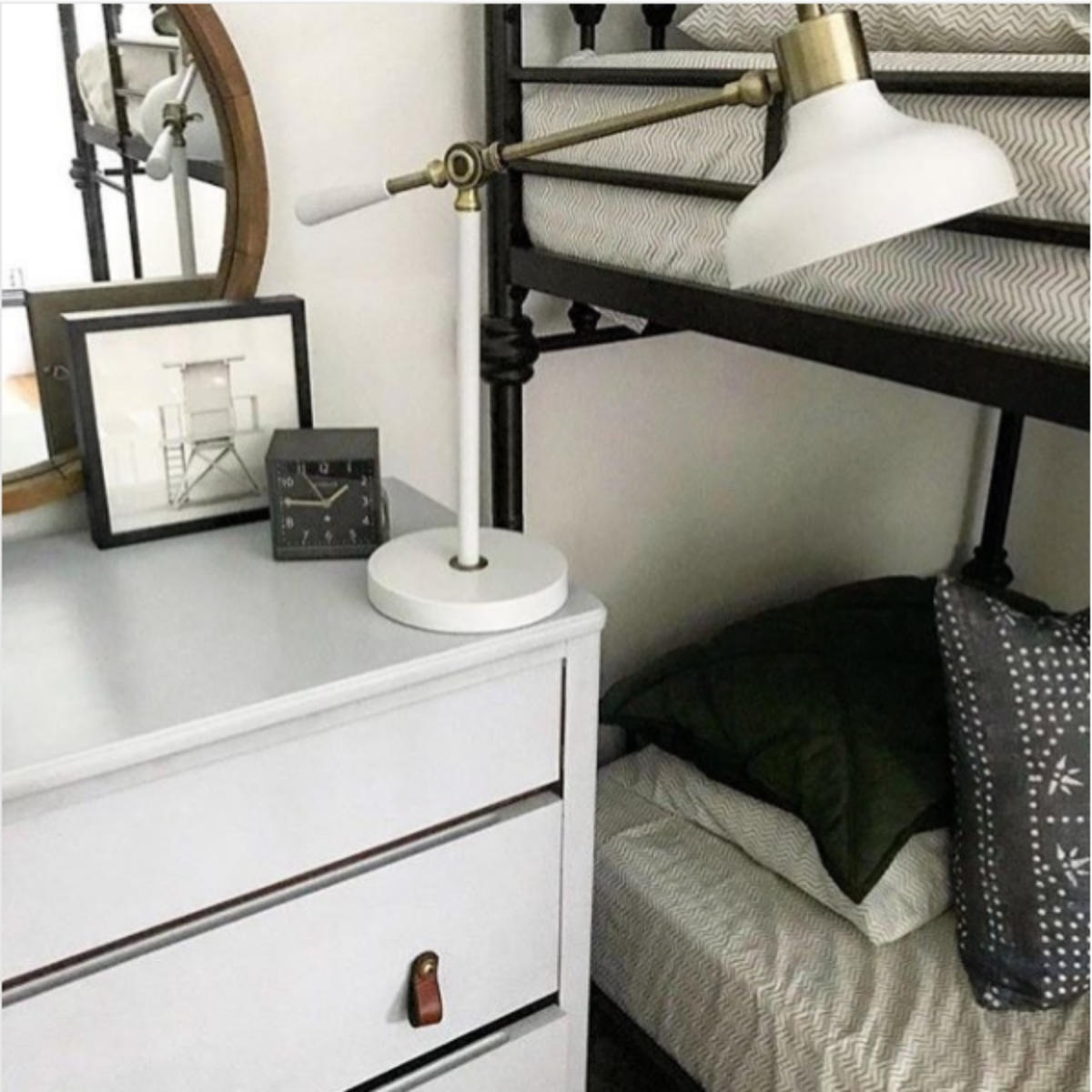 Customer photo of a honey colored Hawthorne small leather pull on a chest of drawers next to a bunk bed. The chest and decor is white and black.