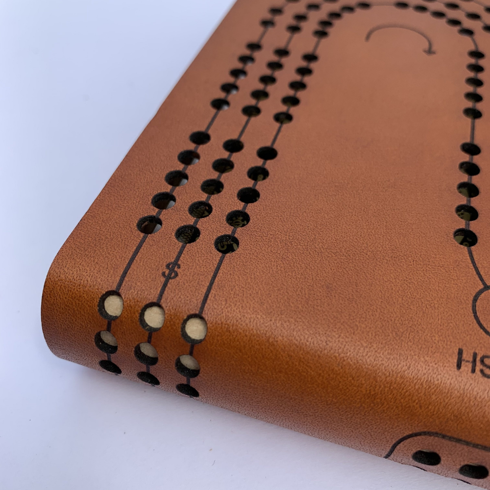 Close-up Image of Lasering Quality Showing the Skunk Line on Leather Travel Cribbage board