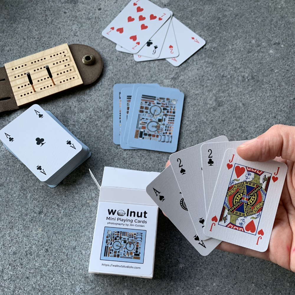 Travel size mini playing cards shown in hand for scale with ultralight gift set