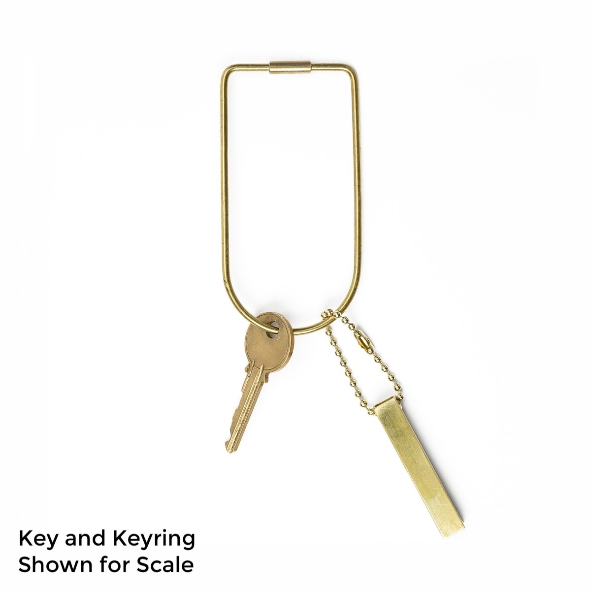 A brass keyring with a key and a set of brass travel dice attached to the keyring. The text on the photo says, &quot;Key and Keyring Shown for Scale&quot;. 